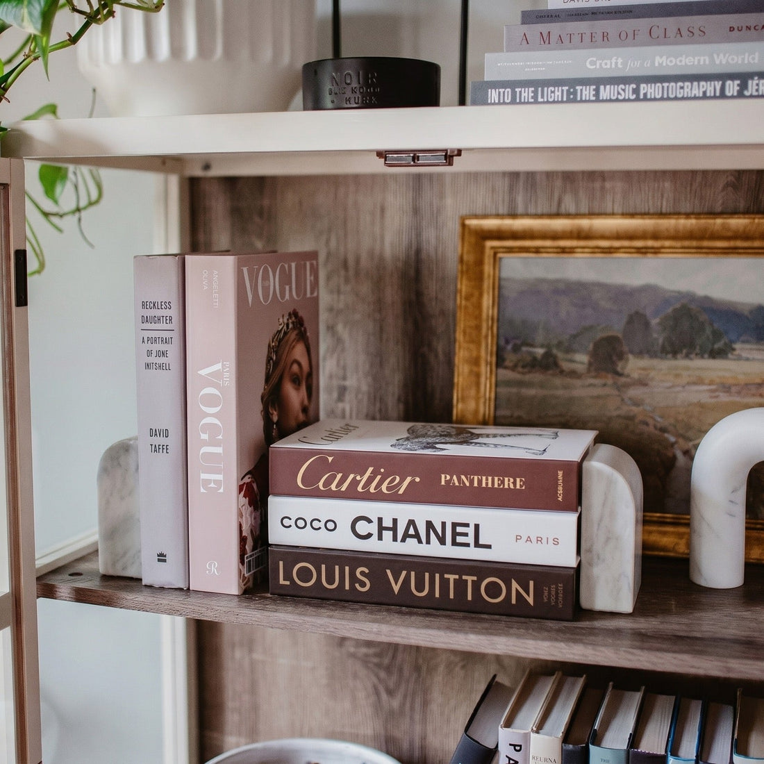 How to Style Coffee Table Books Like a Designer — Decorative books styled on a console with marble bookends