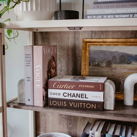How to Style Coffee Table Books Like a Designer — Decorative books styled on a console with marble bookends